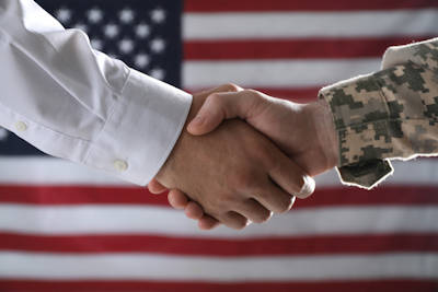 handshake - military and civilian in front of US flag