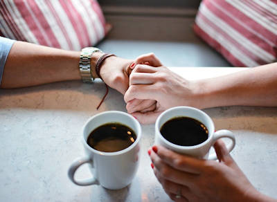 holding hands and sharing coffee